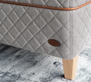 Detail of the DUX 3003 bed and tapered bed legs on a light green carpet. 